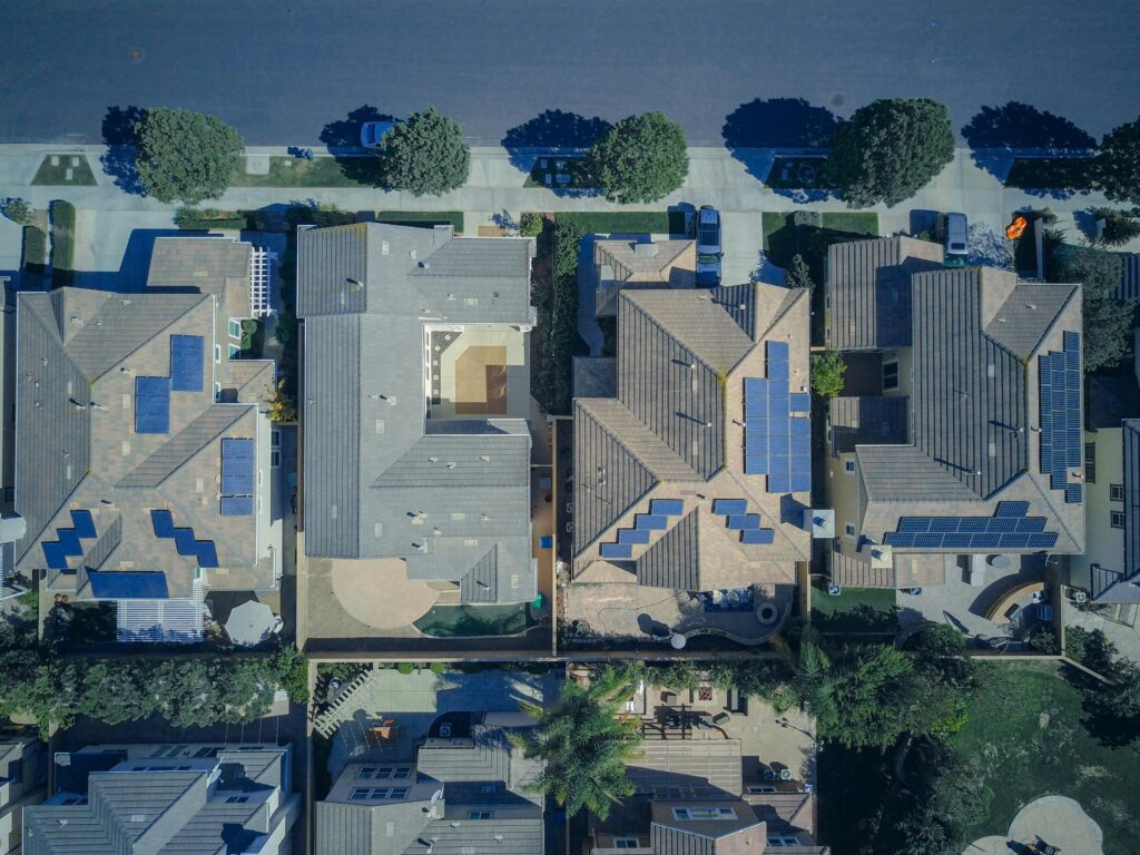 pexels-photo-9875676-9875676 Top-down view of urban houses with solar panels emphasizing clean energy solutions.