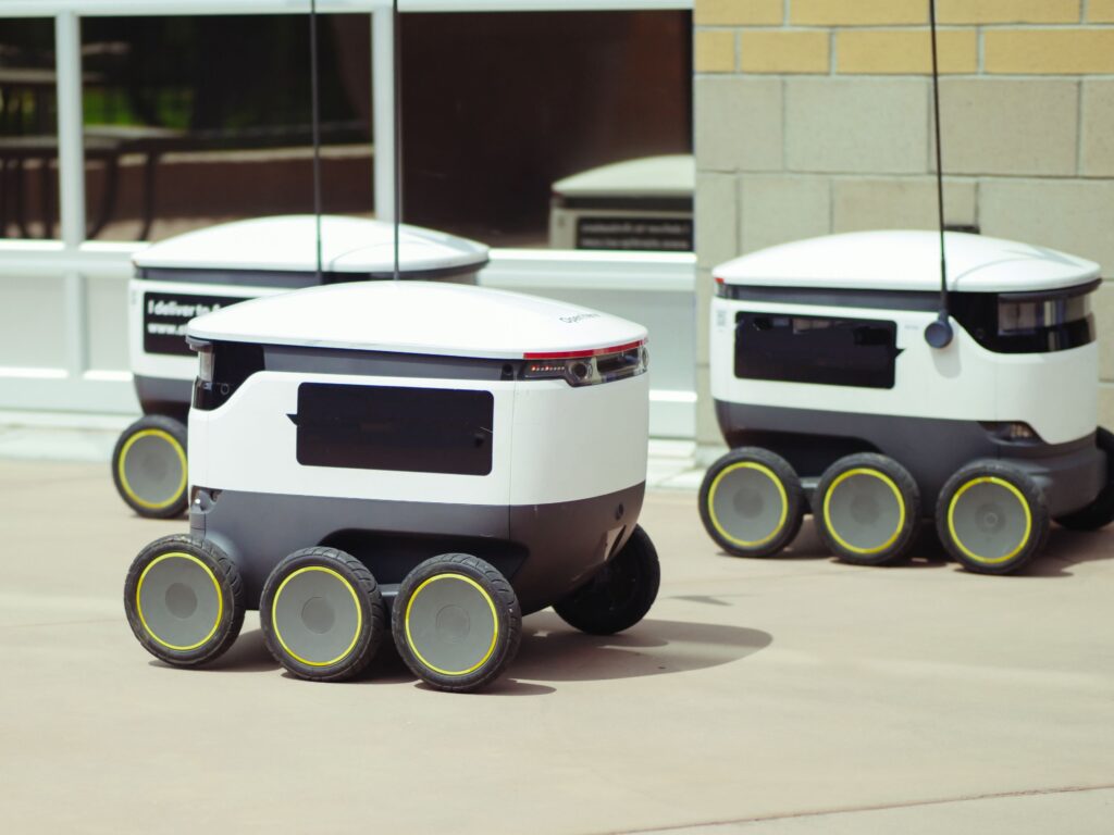 pexels-photo-8566569-8566569 Advanced autonomous delivery robots in an outdoor urban setting, showcasing modern technology.